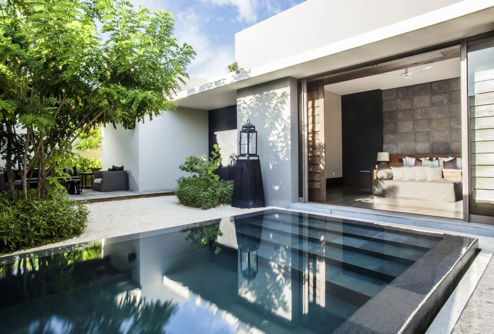 Piscina privada rodeada de vegetación junto a una suite.