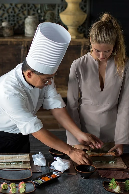 Un chef y una mujer preparan una propuesta culinaria juntos.
