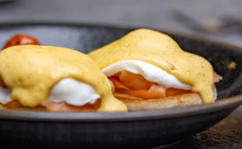 Huevos preparados con salsa sobre una pieza de pan.