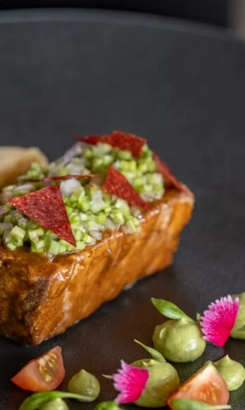 Una tostada con vegetales y guarniciones de colores.